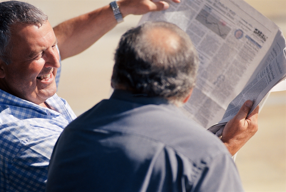 Men reading newspaper.